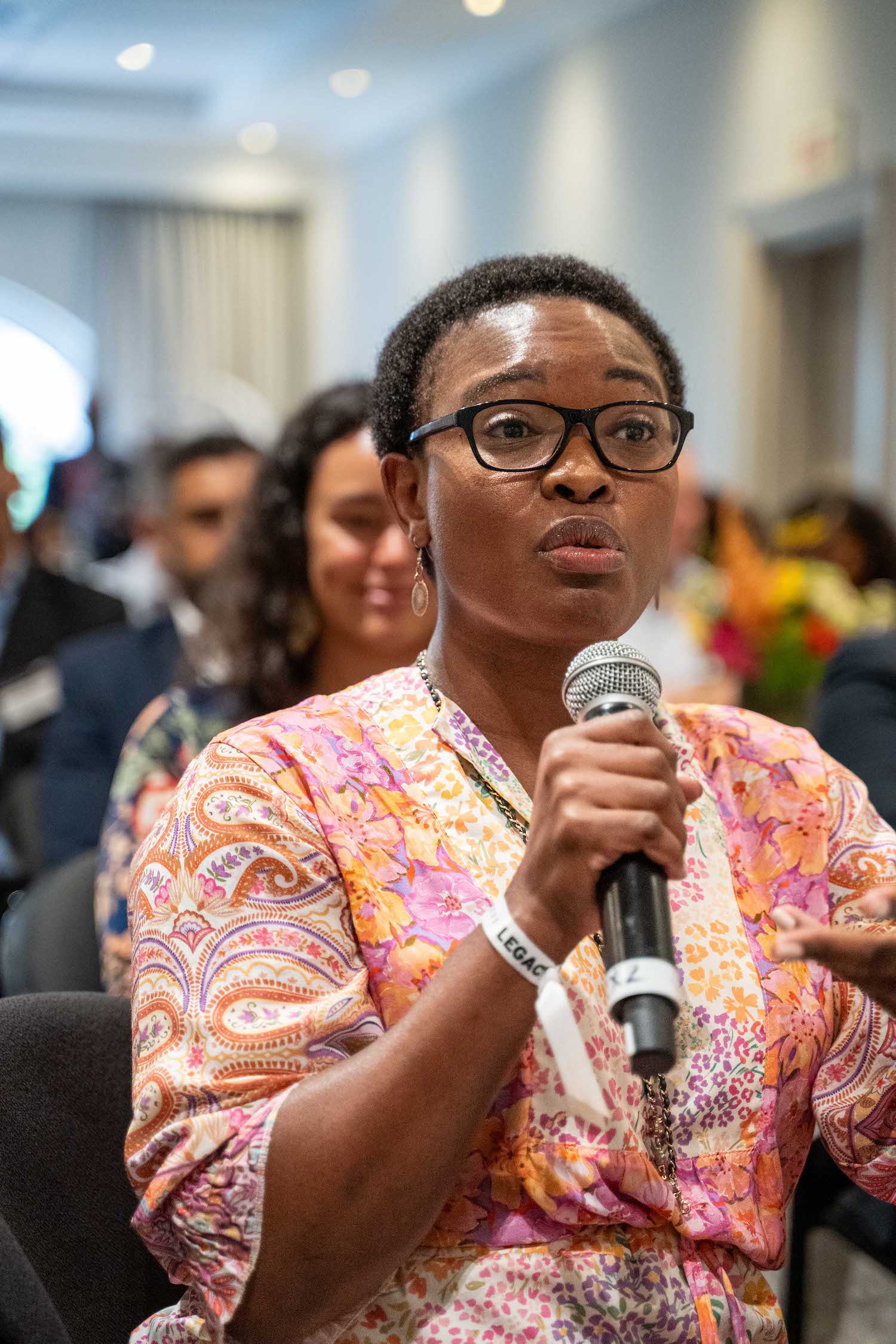 Event photographer capturing an attendee asking a question at a conference