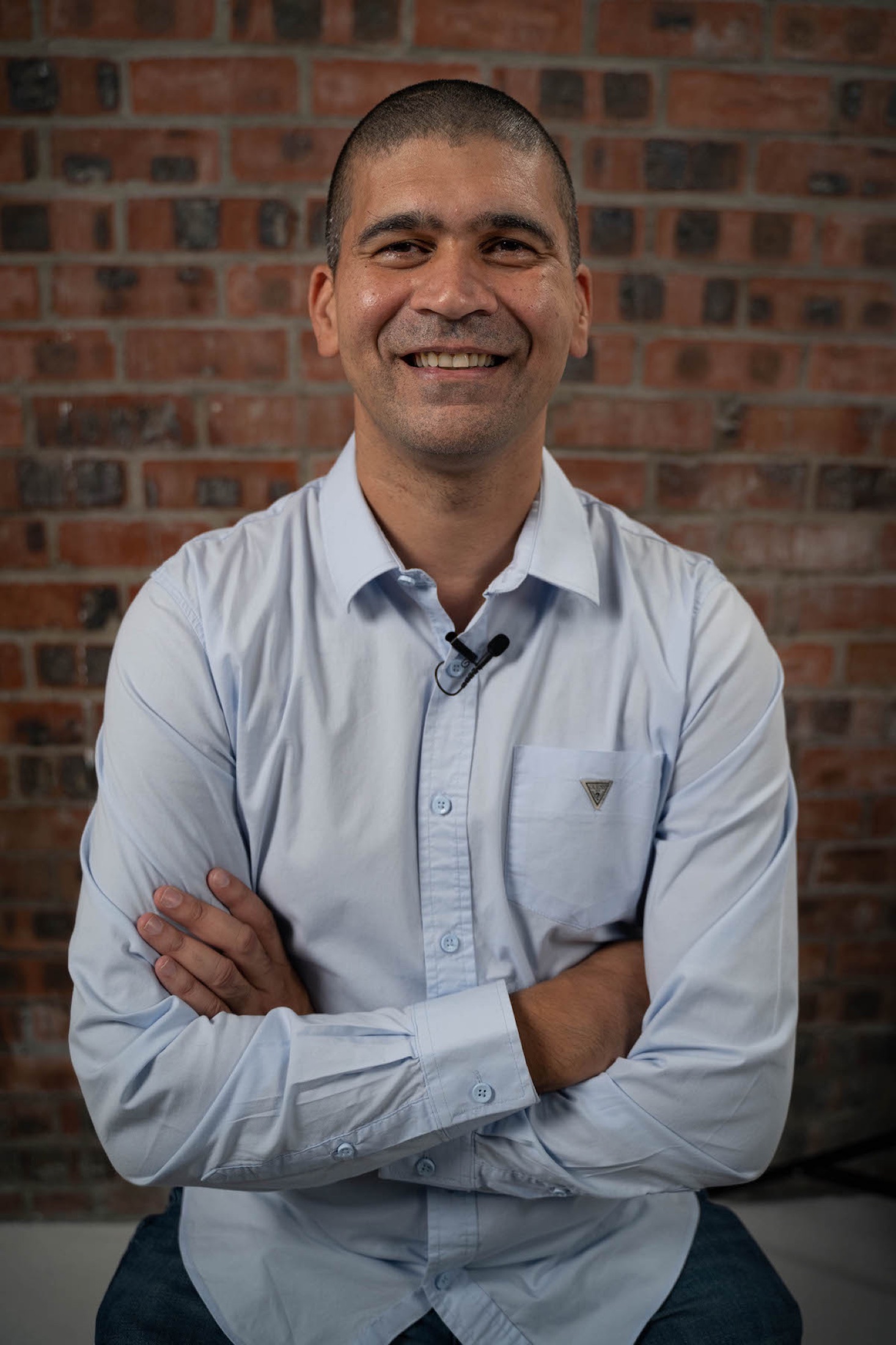 On-site headshot at client office, brick wall backdrop, Cape Town