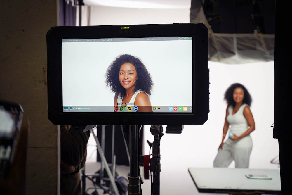 On-set monitor showing talent during a behind-the-scenes video production moment